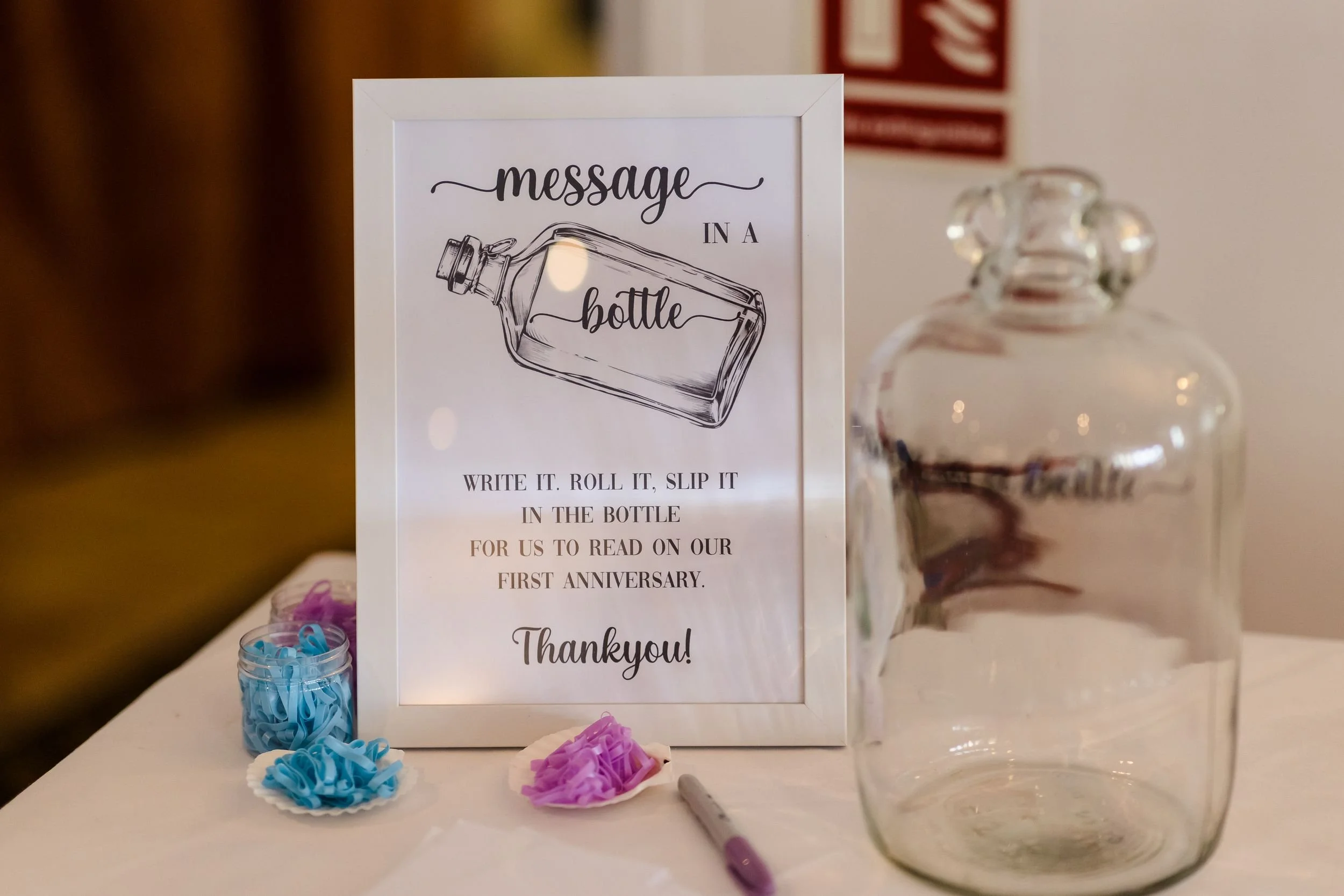 Message in a bottle guest book sign and glass bottle at Katie and Tom's Berry Head Hotel wedding