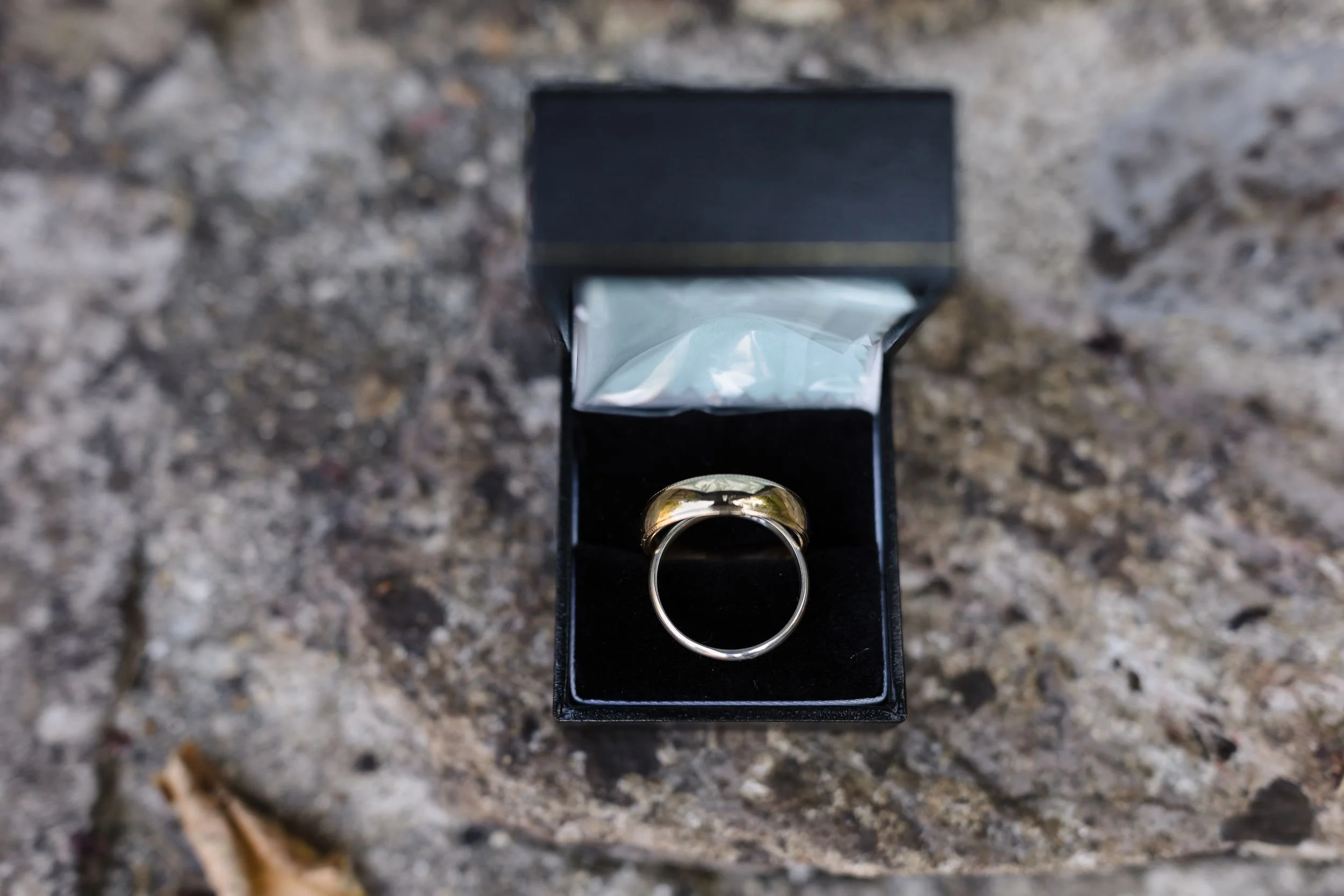 Gold wedding ring in an open ring box on a stone step at Berry Head Hotel