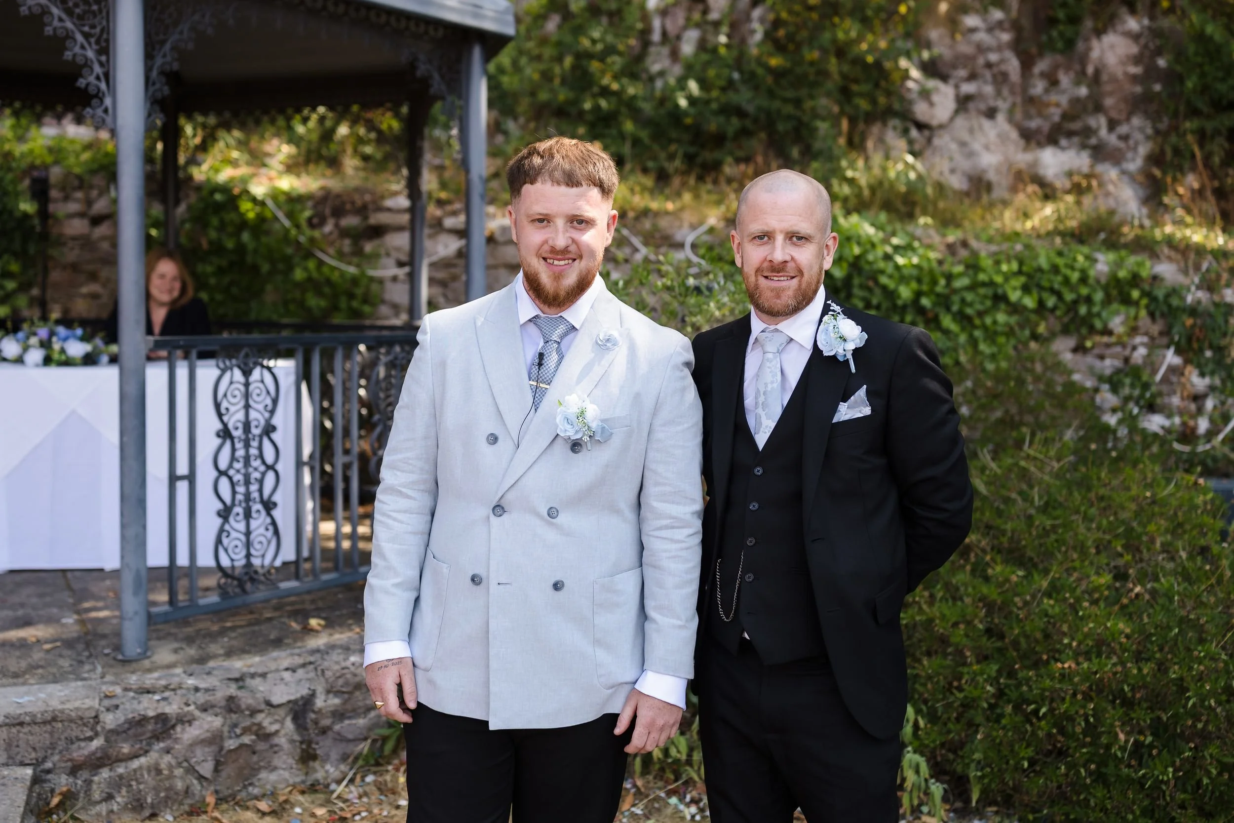 Groom in a pale grey jacket and his best man beside the gazebo before the ceremony at Berry Head Hotel