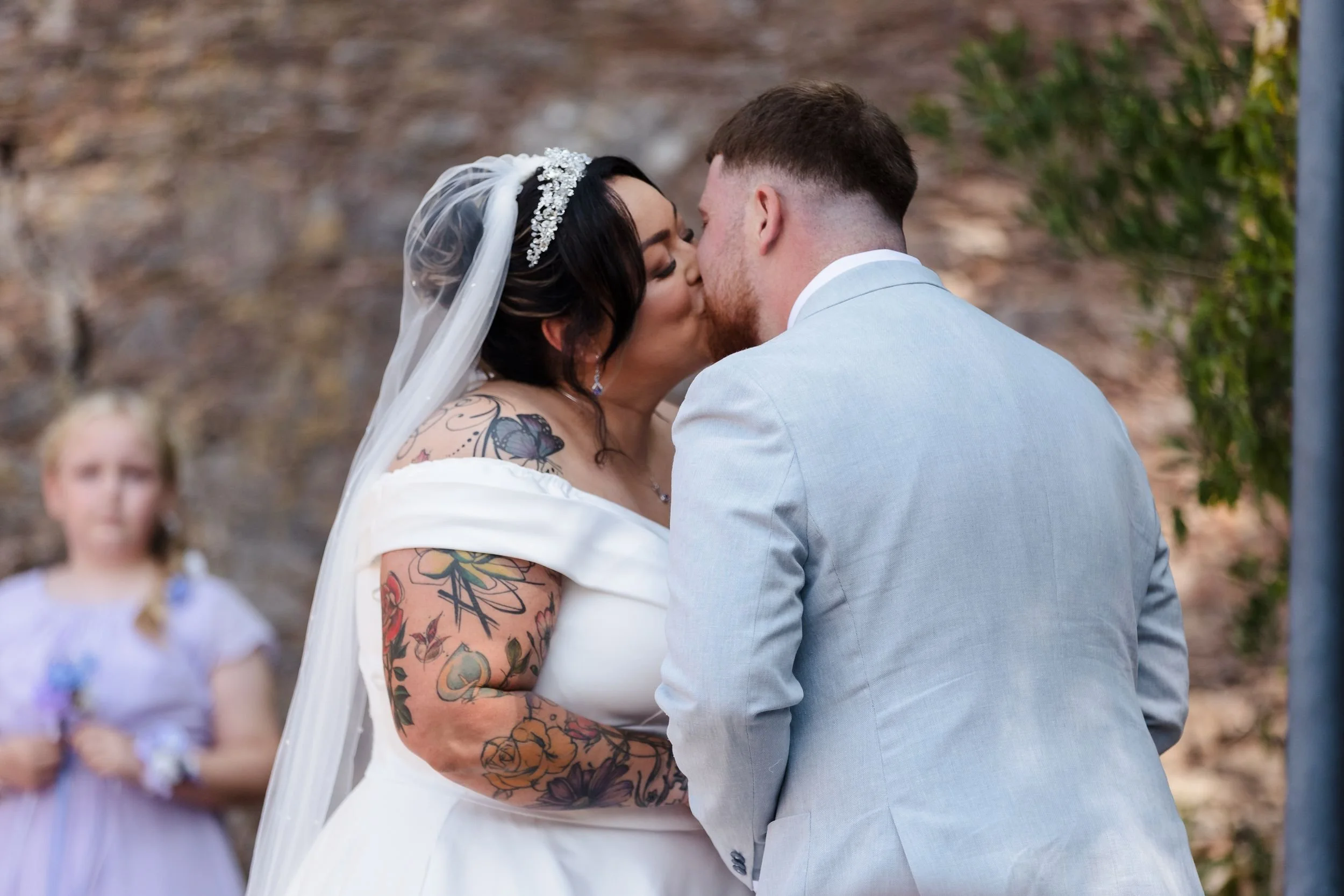Close-up of the bride and groom's first kiss during their outdoor ceremony at Berry Head Hotel, Brixham