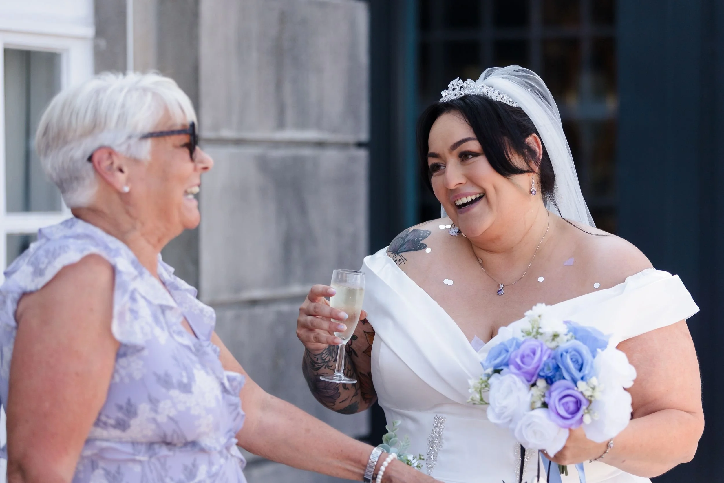 Bride laughs with a guest during the drinks reception at her Berry Head Hotel wedding