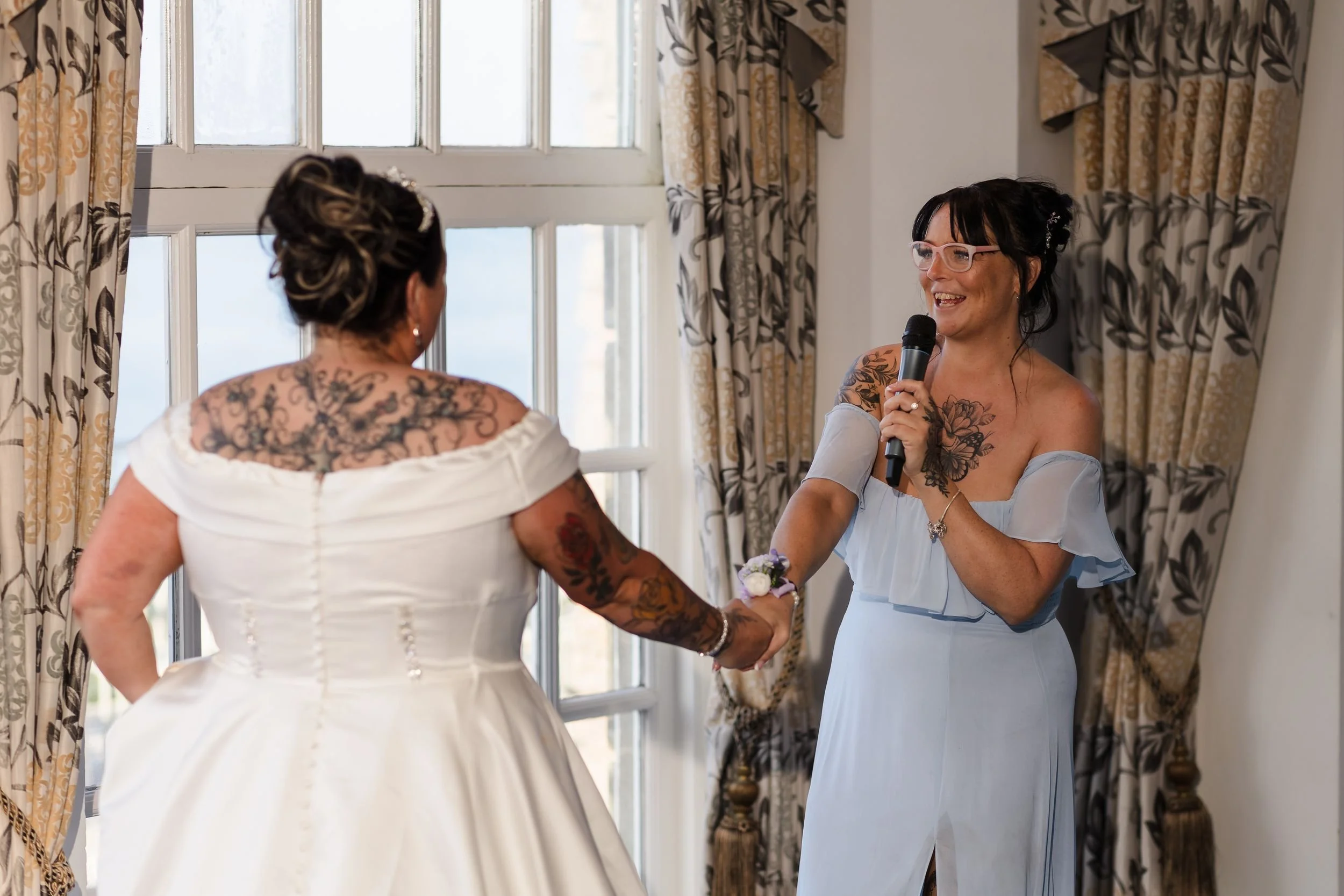 Bridesmaid holds the bride's hand while giving a speech at a Berry Head Hotel wedding