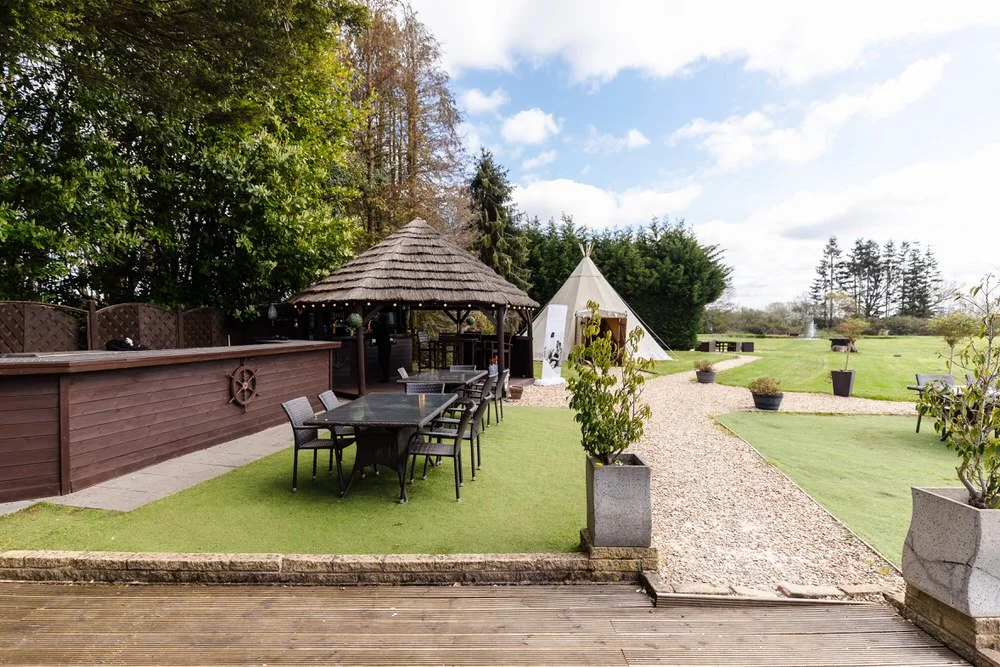 Gravel aisle leading to thatched outdoor ceremony gazebo at The Limes Country Lodge, Earlswood — wedding photography by Once in a Lifetime Photography