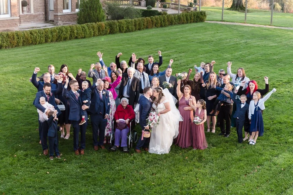 Full wedding guest group photo on lawns at Bredenbury Court Barns
