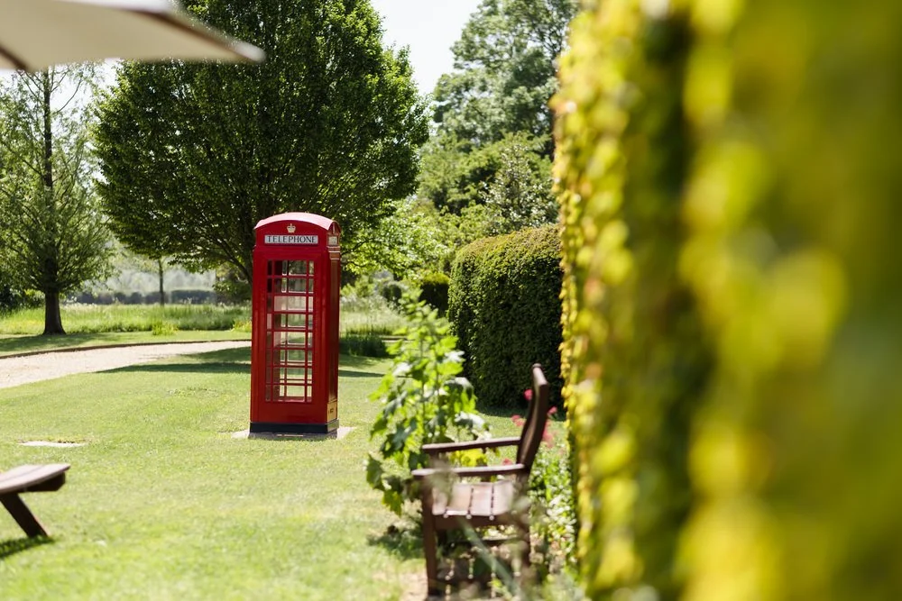 Vintage red telephone box in the gardens at Huntsmill Farm, a popular wedding photo spot.