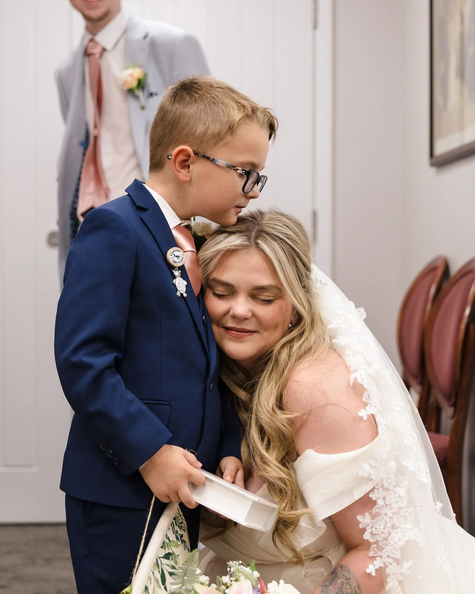 The bride's son hugging her after seeing her in her dress at Lichfield Registry Office, wedding photography by Once in a Lifetime Photography.