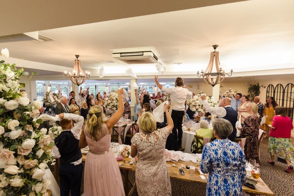 Wedding guests cheering during singer waiter surprise performance at Hogarths Stone Manor, documentary wedding photography