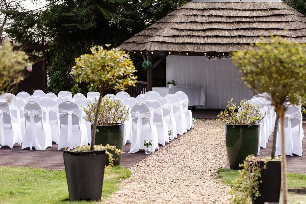Outdoor wedding ceremony chairs and thatched gazebo at The Limes Country Lodge, Earlswood Solihull — candid wedding photography by Paul Hickey