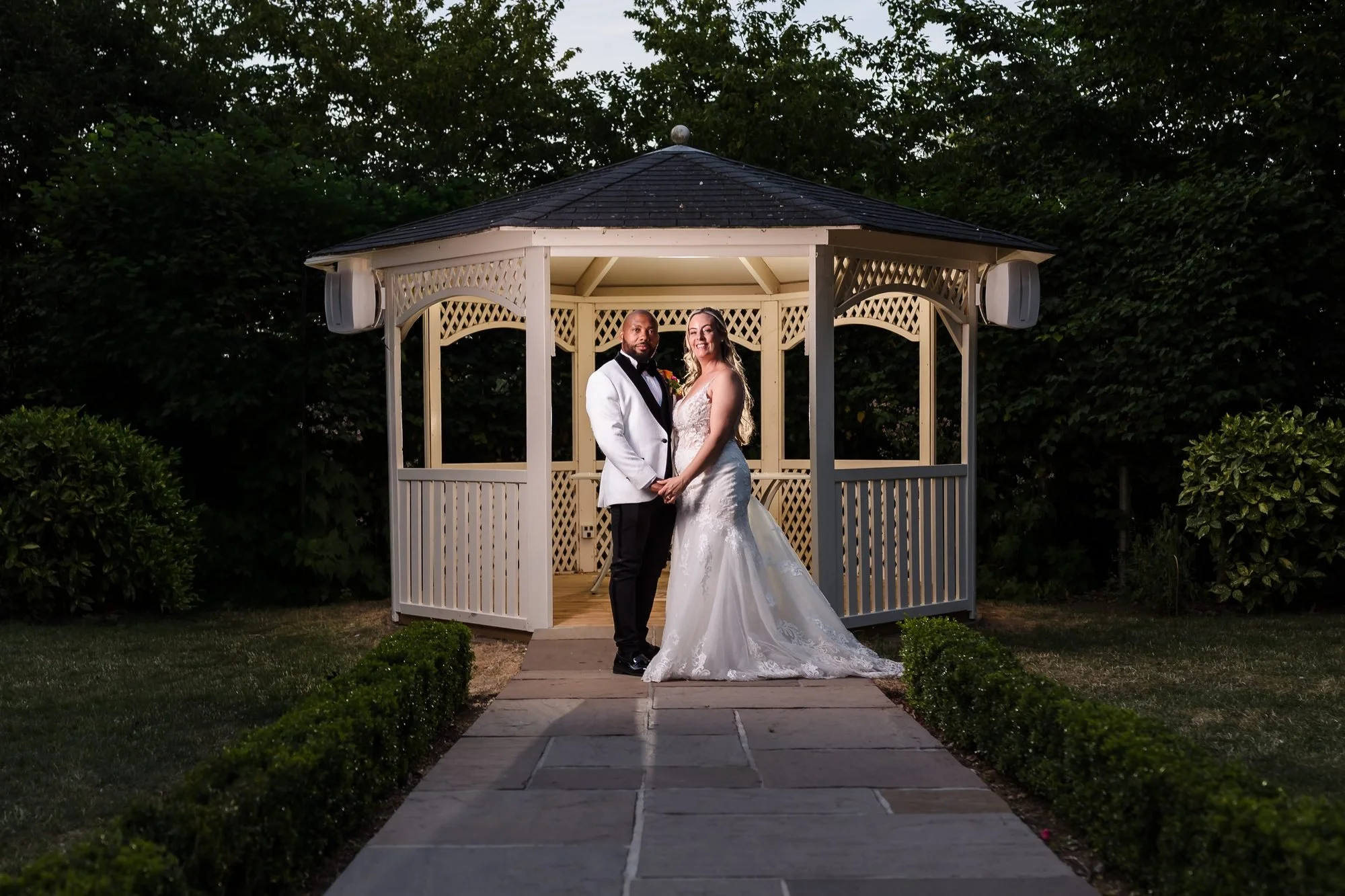 Evening portrait of Angela and Tafarie in the garden gazebo at Warwick House – wedding photography by Once in a Lifetime Photography