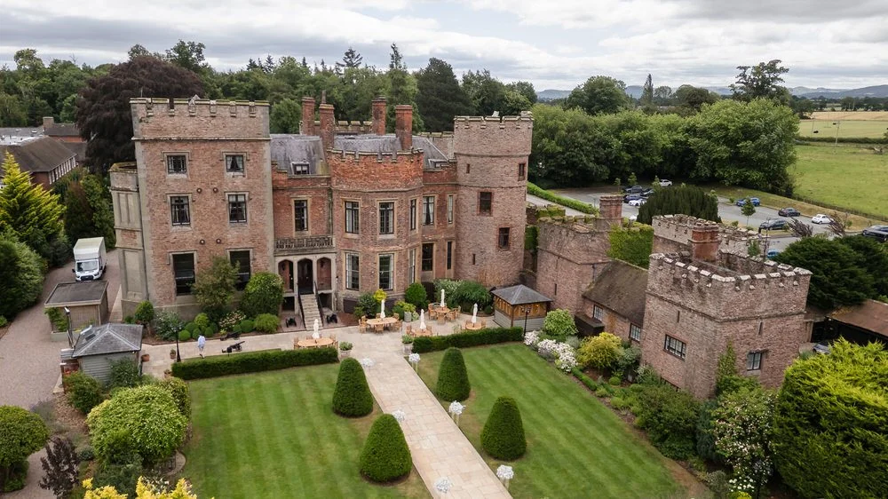 Aerial view of Rowton Castle wedding venue in Shropshire, showing the castle towers and formal lawns