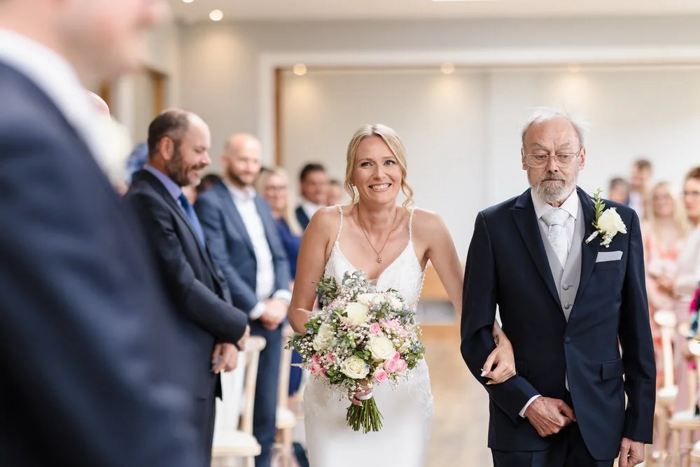 Bride walking down aisle in Bredenbury Court Orangery ceremony by Herefordshire wedding photographer