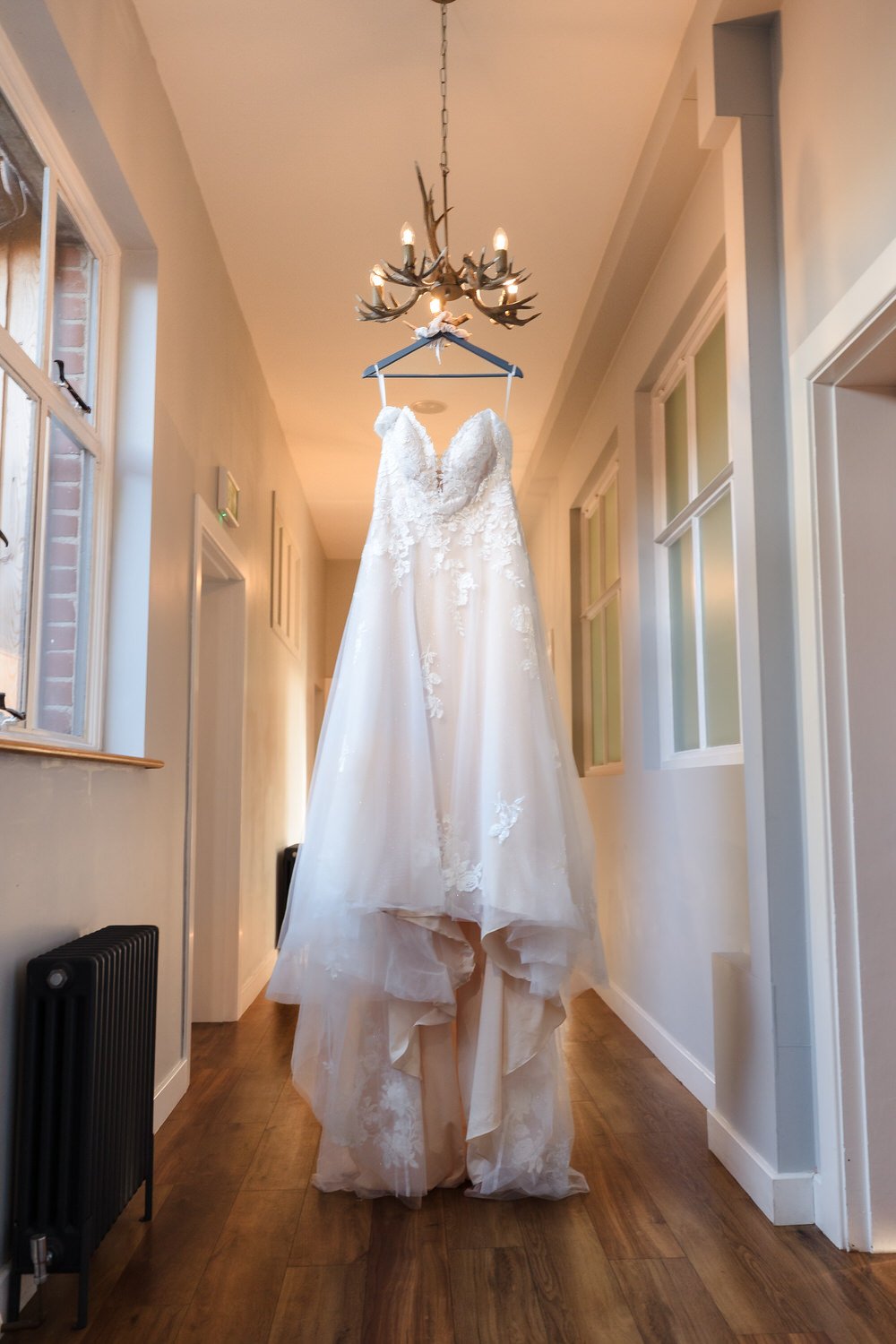 Wedding dress hanging in hallway at Bredenbury Court Barns bridal suite