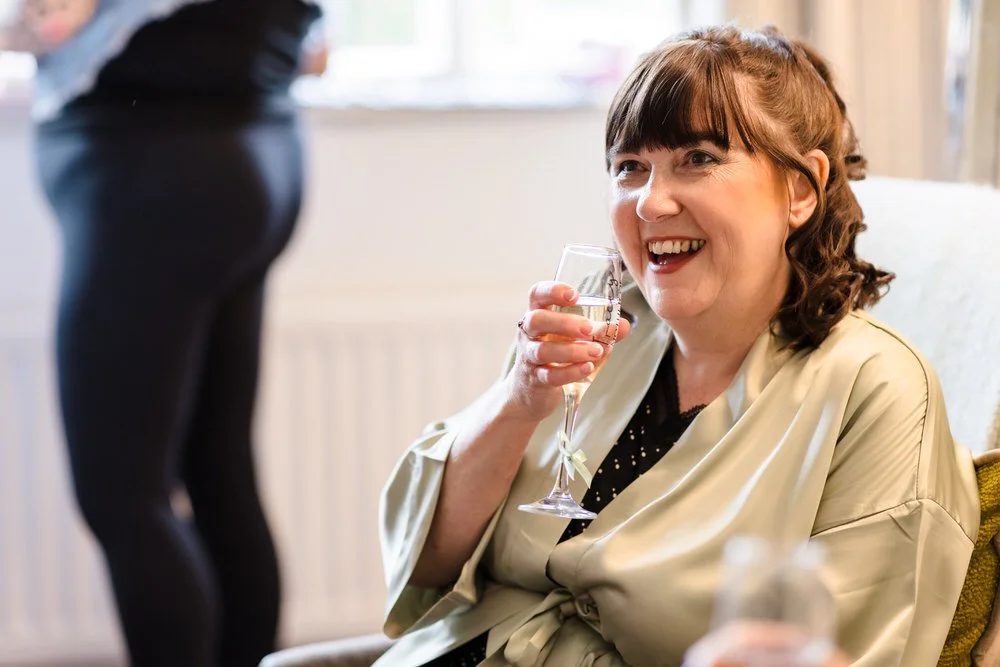 Mother of the groom drinking champagne while getting ready for a Hogarths Stone Manor wedding
