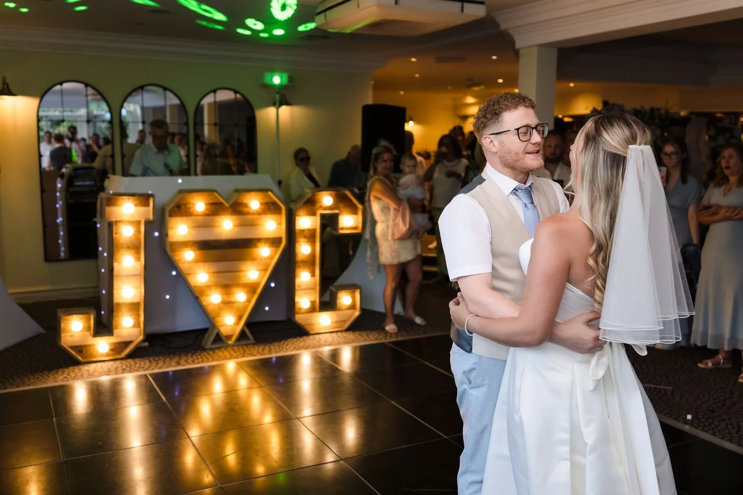 Cheryl and Josh's first dance beside giant light-up J and C letters and a heart