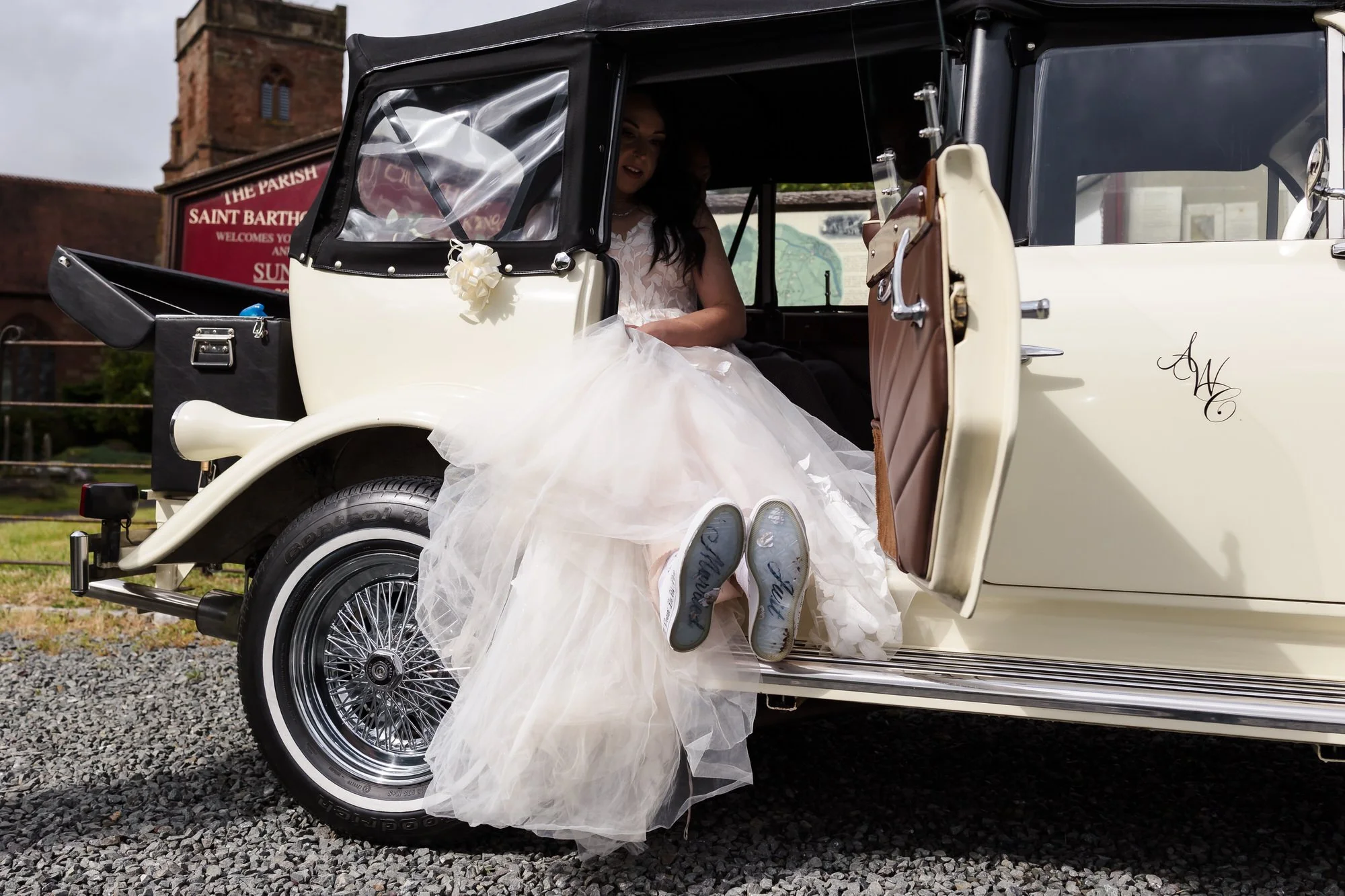 Bride stepping from a vintage wedding car outside St Bartholomew's Church, Stourport-on-Severn.