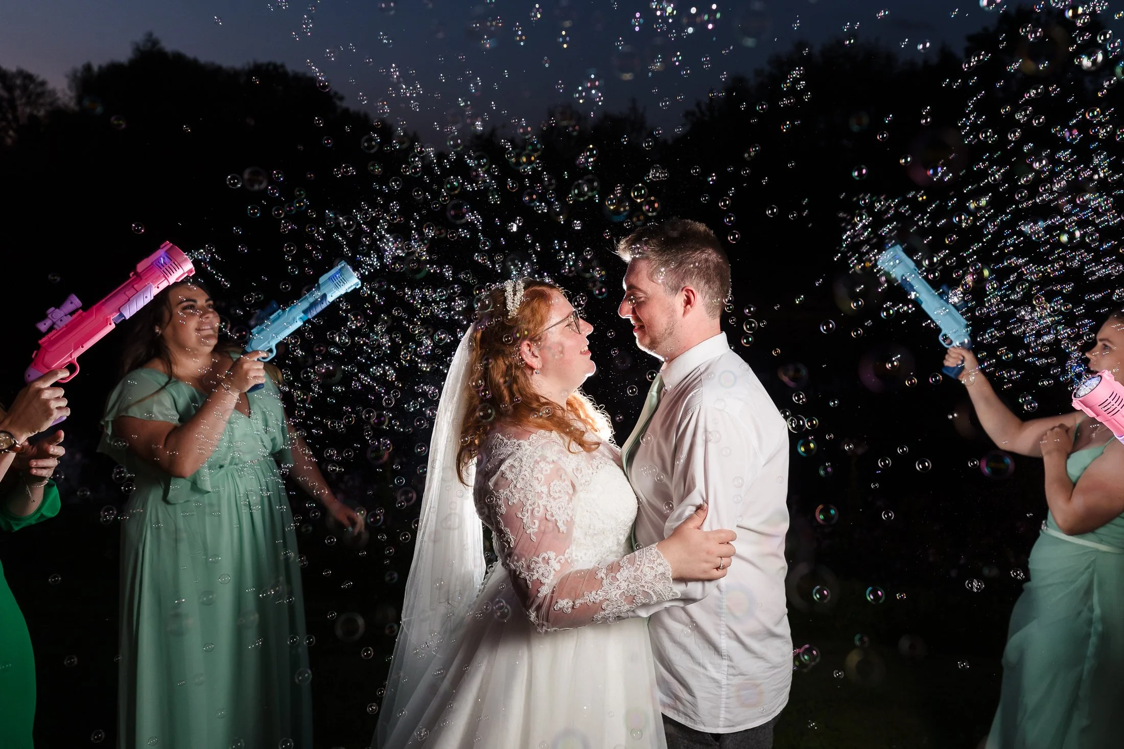 bride and grrom sprayed with bubbles by bridal party at wedding