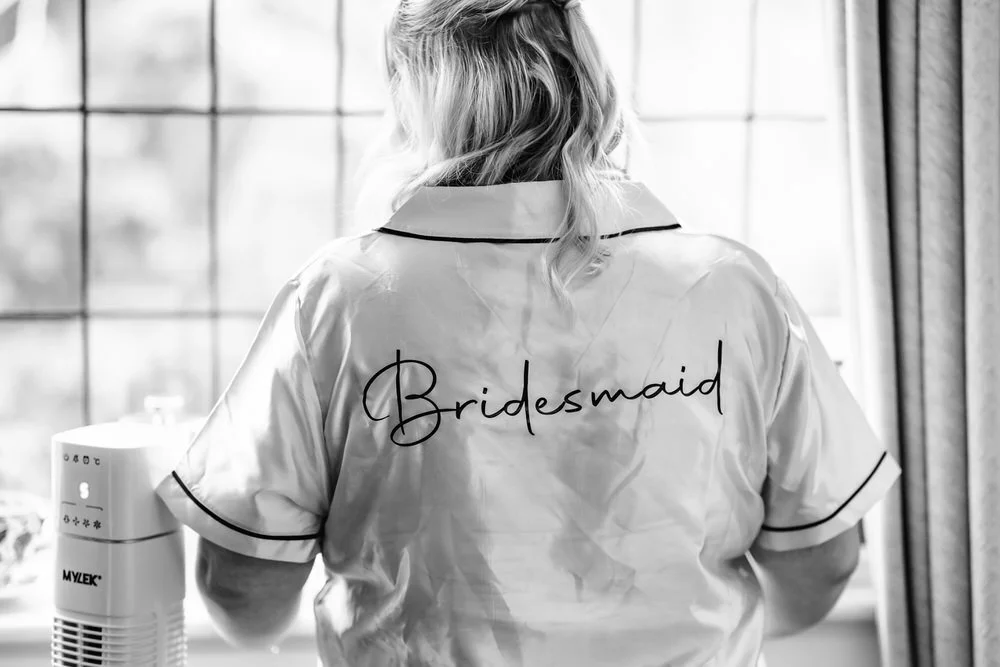 Bridesmaid getting ready in robe at Hogarths Stone Manor, black and white wedding photography