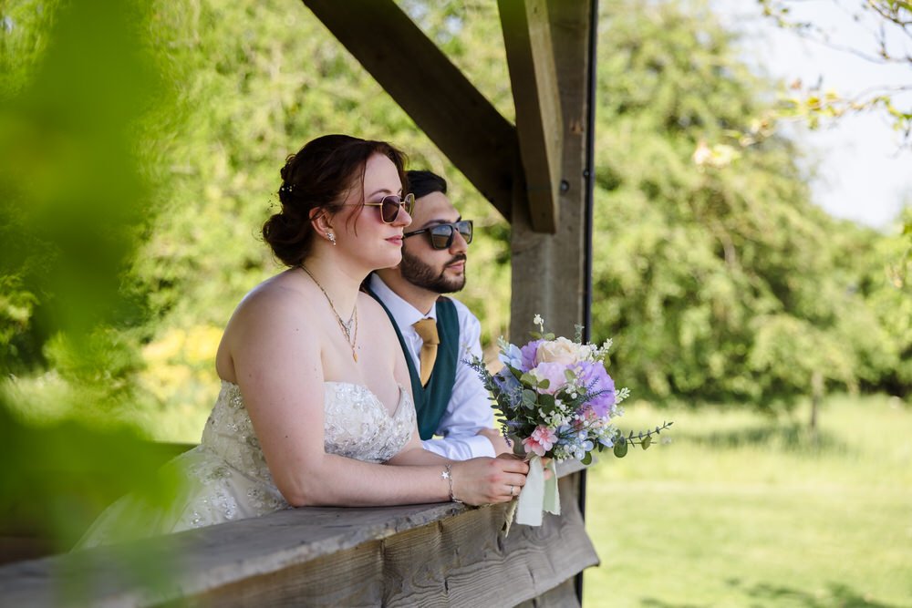 Bride and groom looking out from inside The Shed at Huntsmill Farm, Buckinghamshire.