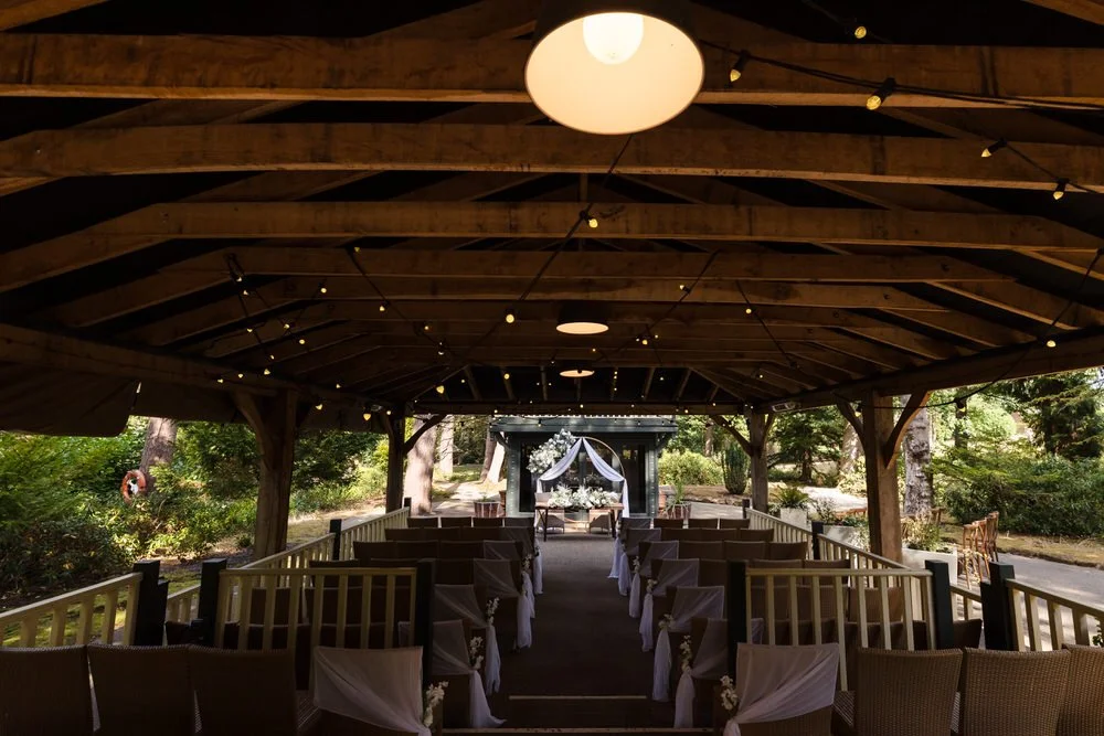 Outdoor wedding ceremony setup beneath a wooden pavilion at Hogarths Hotel wedding venue.