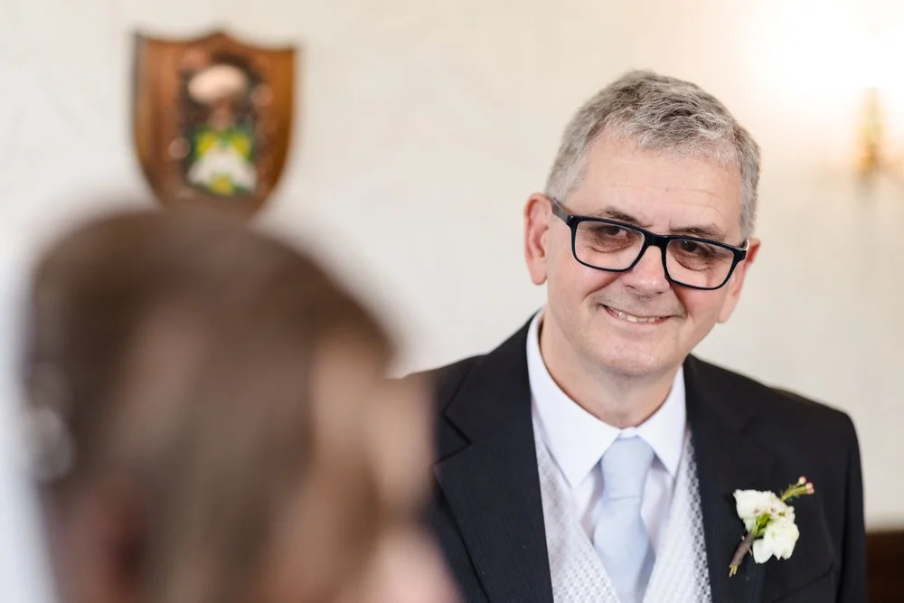 Father of the bride smiling warmly during an emotional first look at Karma Salford Hall.