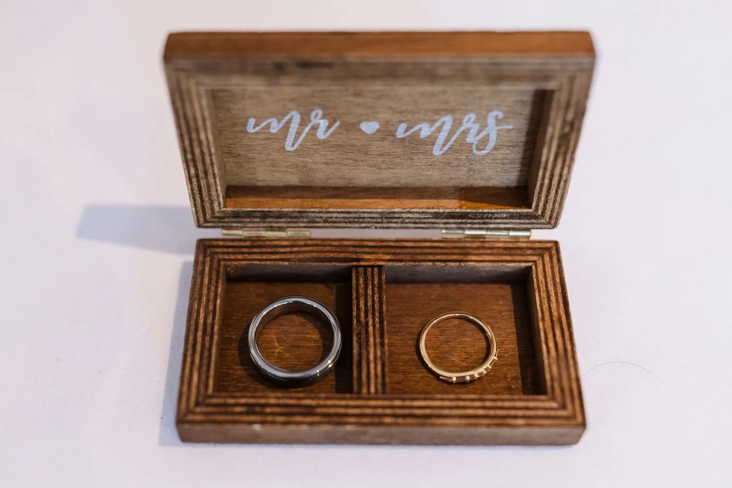 Cheryl and Josh's wedding rings in a wooden Mr and Mrs ring box