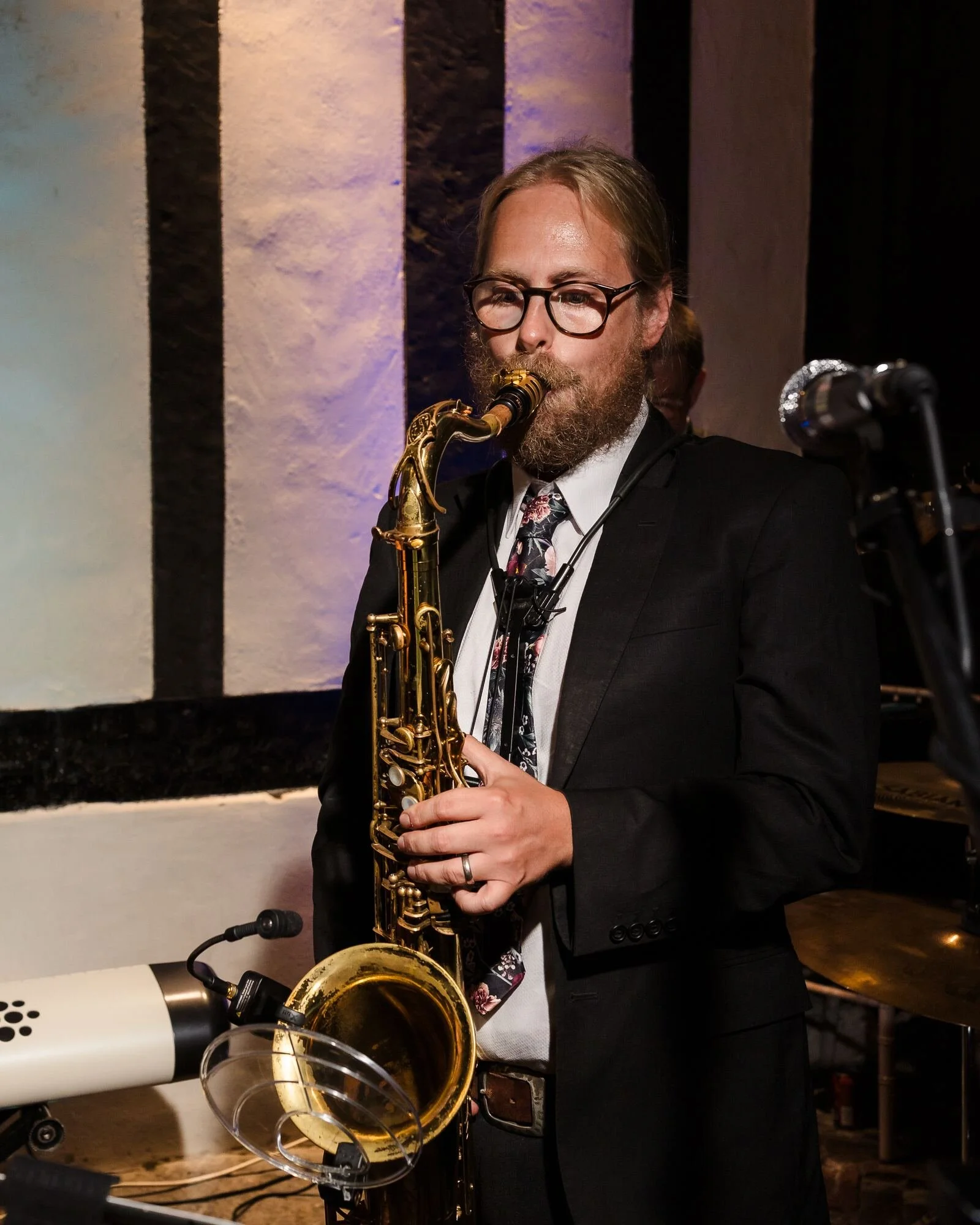 Swing band saxophonist playing under coloured lighting at the evening reception at The Commandery, Worcester, by Once in a Lifetime Photography