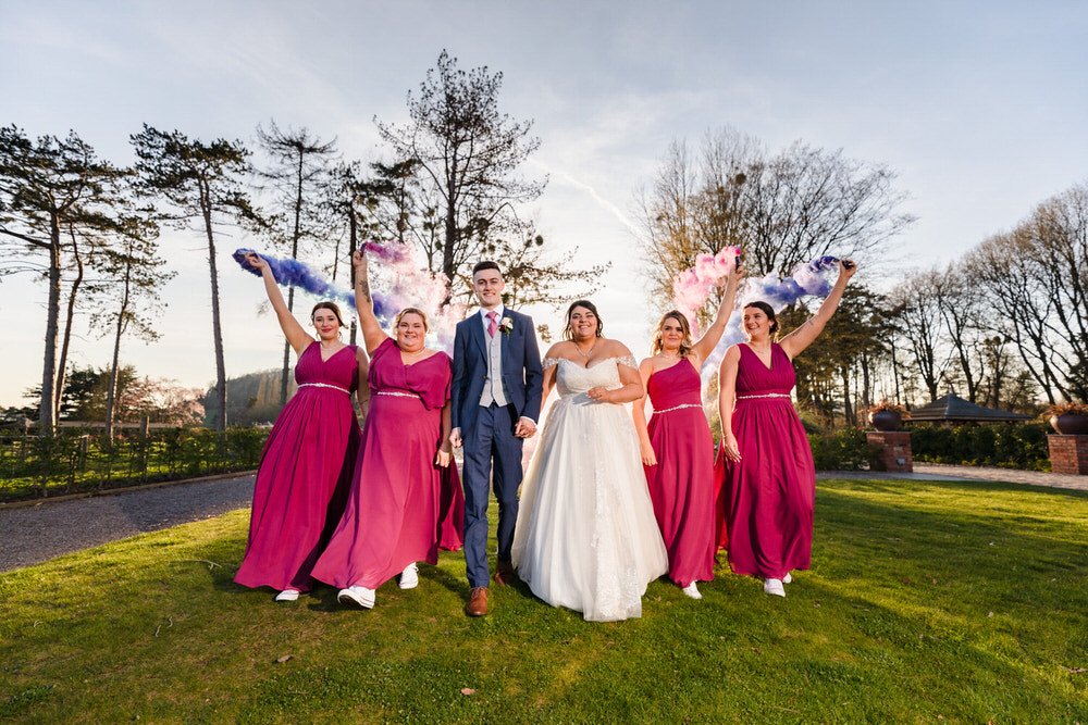 bridal party walking with smoke bombs