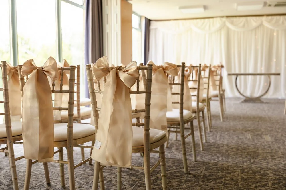 Ceremony seating with gold sashes ready for a wedding at De Vere Cotswold Water Park