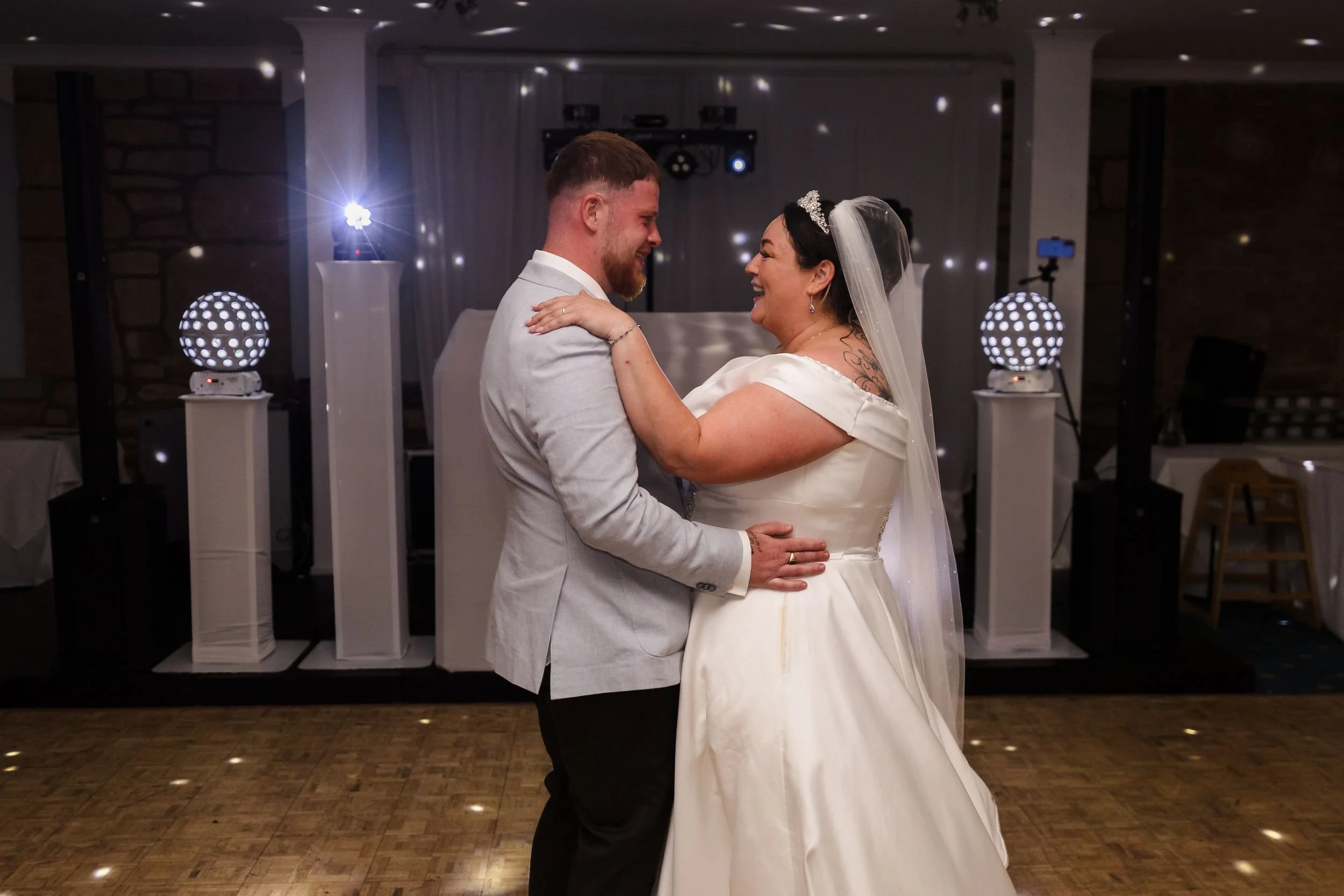 Bride and groom laugh during their first dance in the Mulberry Room at Berry Head Hotel