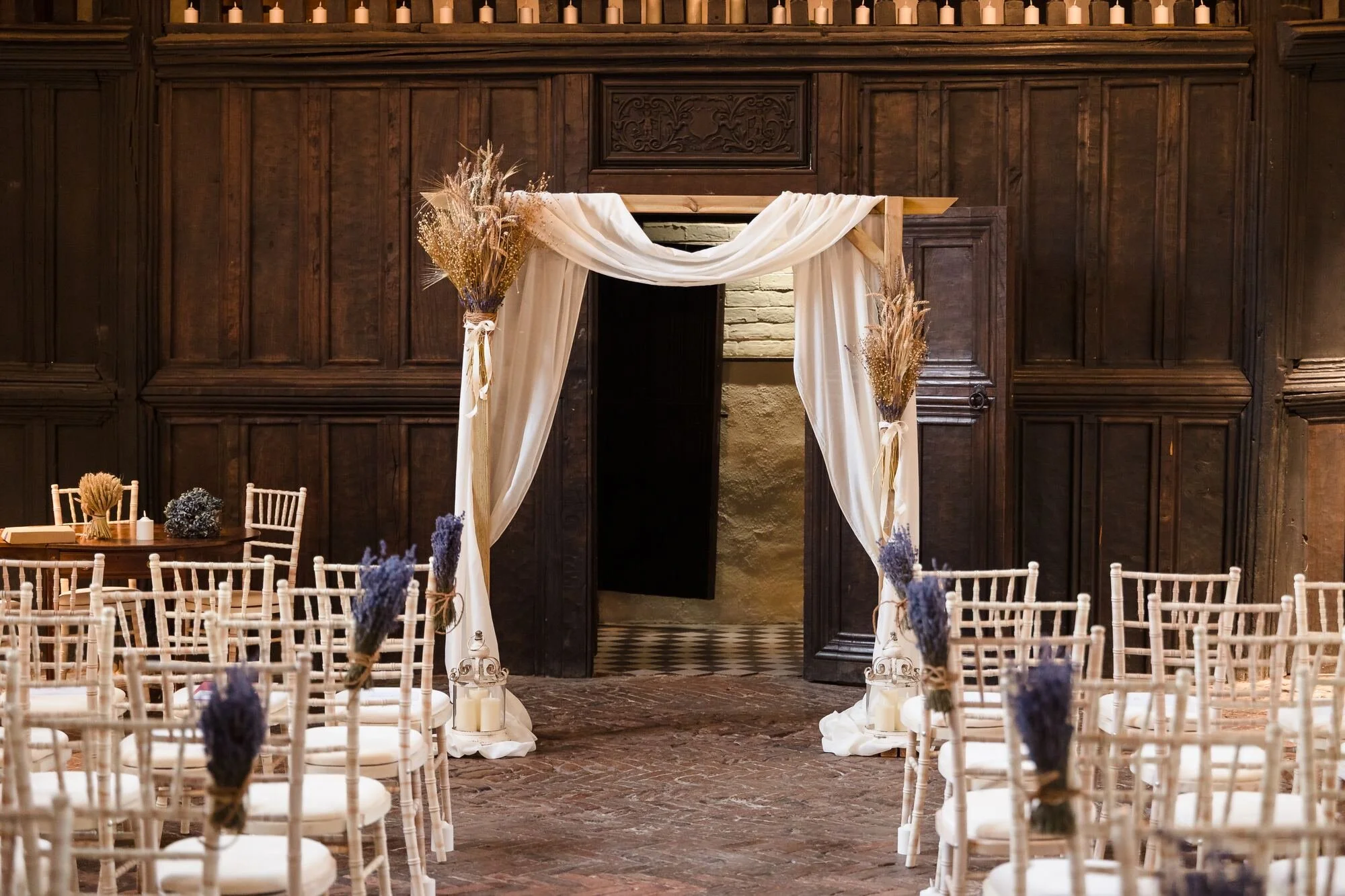 Ceremony arch with dried flowers against the oak panelling of the Great Hall at The Commandery, Worcester, by Once in a Lifetime Photography
