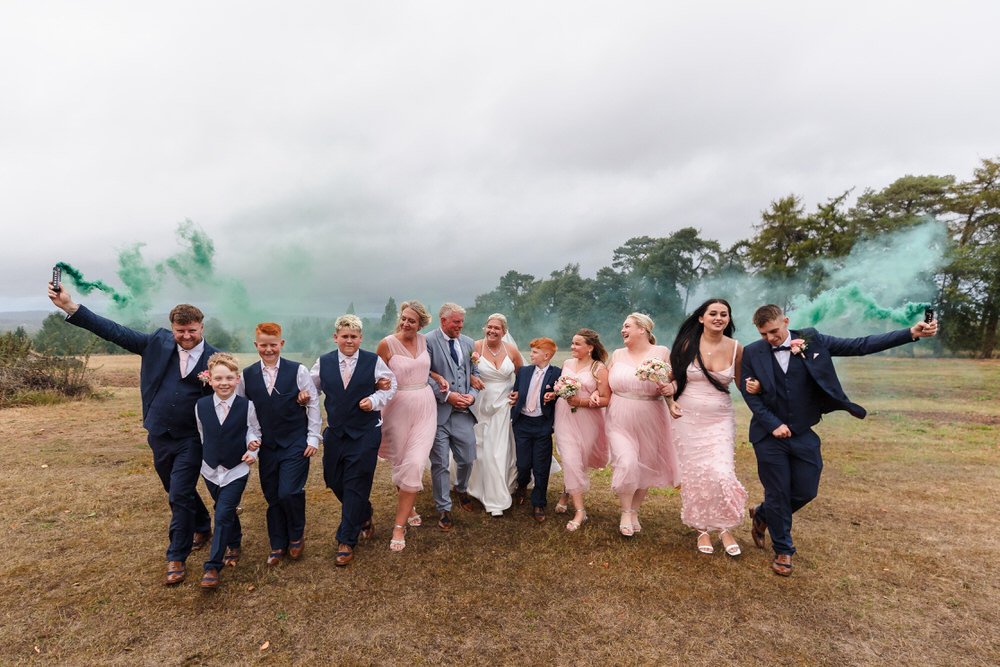 Bridal party with green smoke bombs in Hogarths Stone Manor grounds, creative wedding photography