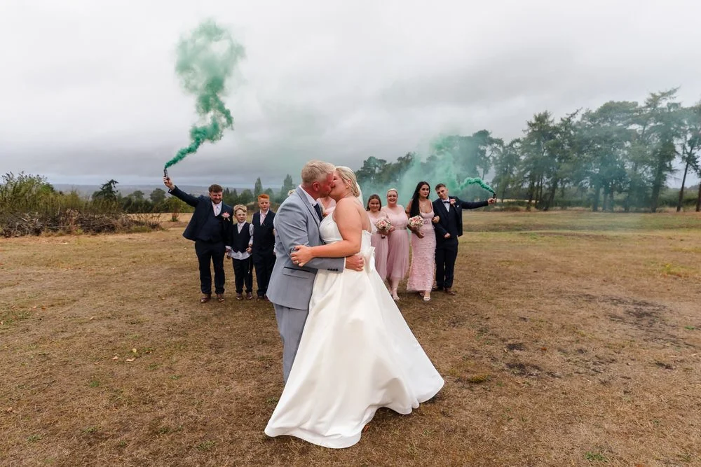 Jess and Brian kissing with smoke bomb backdrop at Hogarths Stone Manor, creative wedding photography
