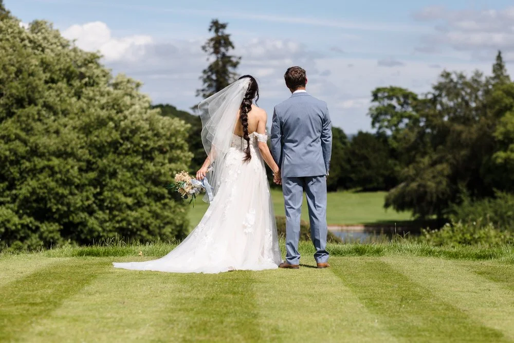 Christine and Greg looking out across the golf course at The Welcombe Hotel, Warwickshire, on their wedding day.