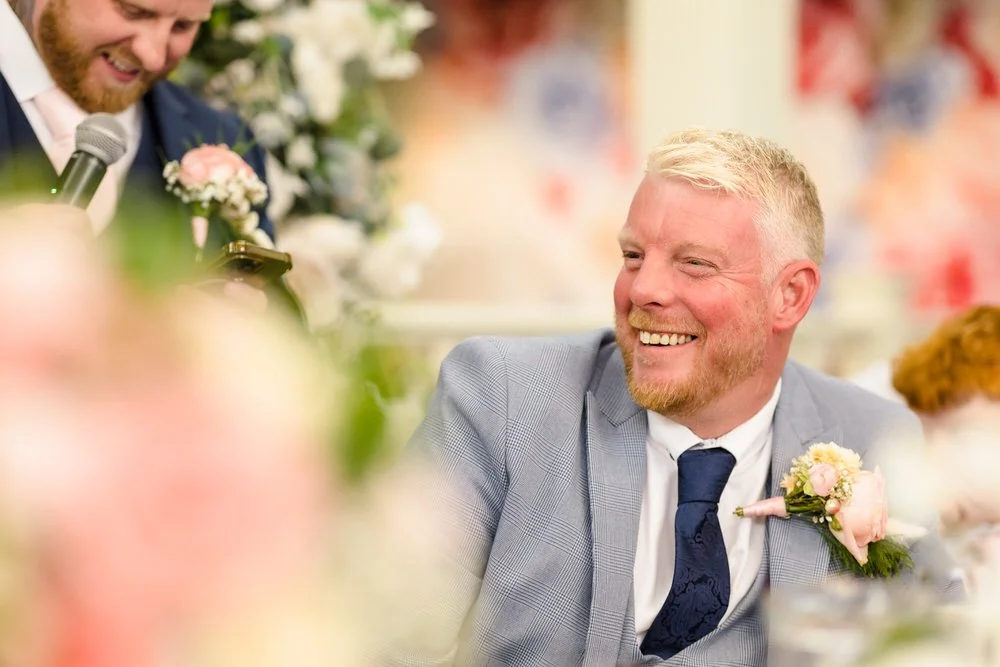 Groom Brian laughing during speeches at Hogarths Stone Manor reception, candid wedding photography