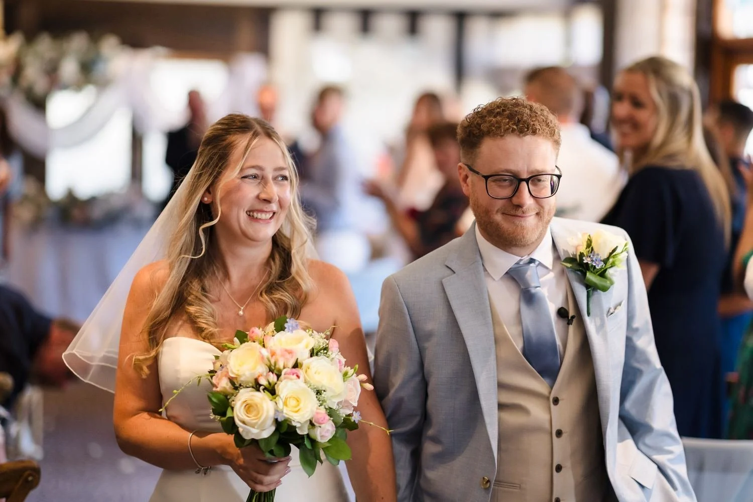 Cheryl and Josh smiling as they leave the ceremony as a married couple