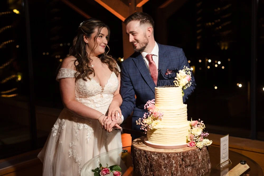 Bride and groom cutting wedding cake at Bredenbury Court Barns reception