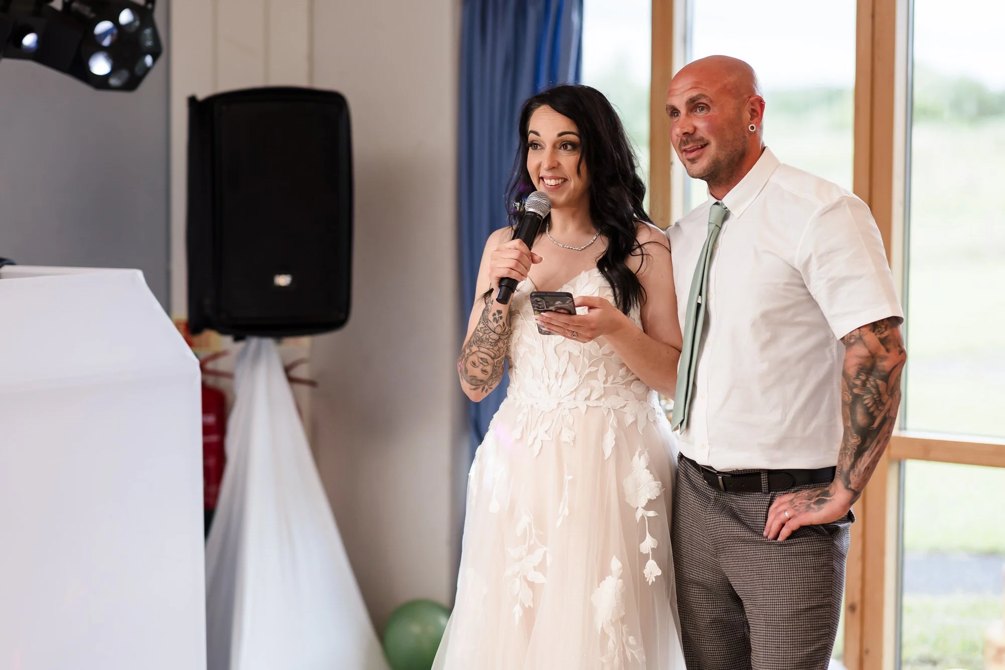Bride giving a speech at her wedding reception at Stourport Sports Club, groom stood beside her.