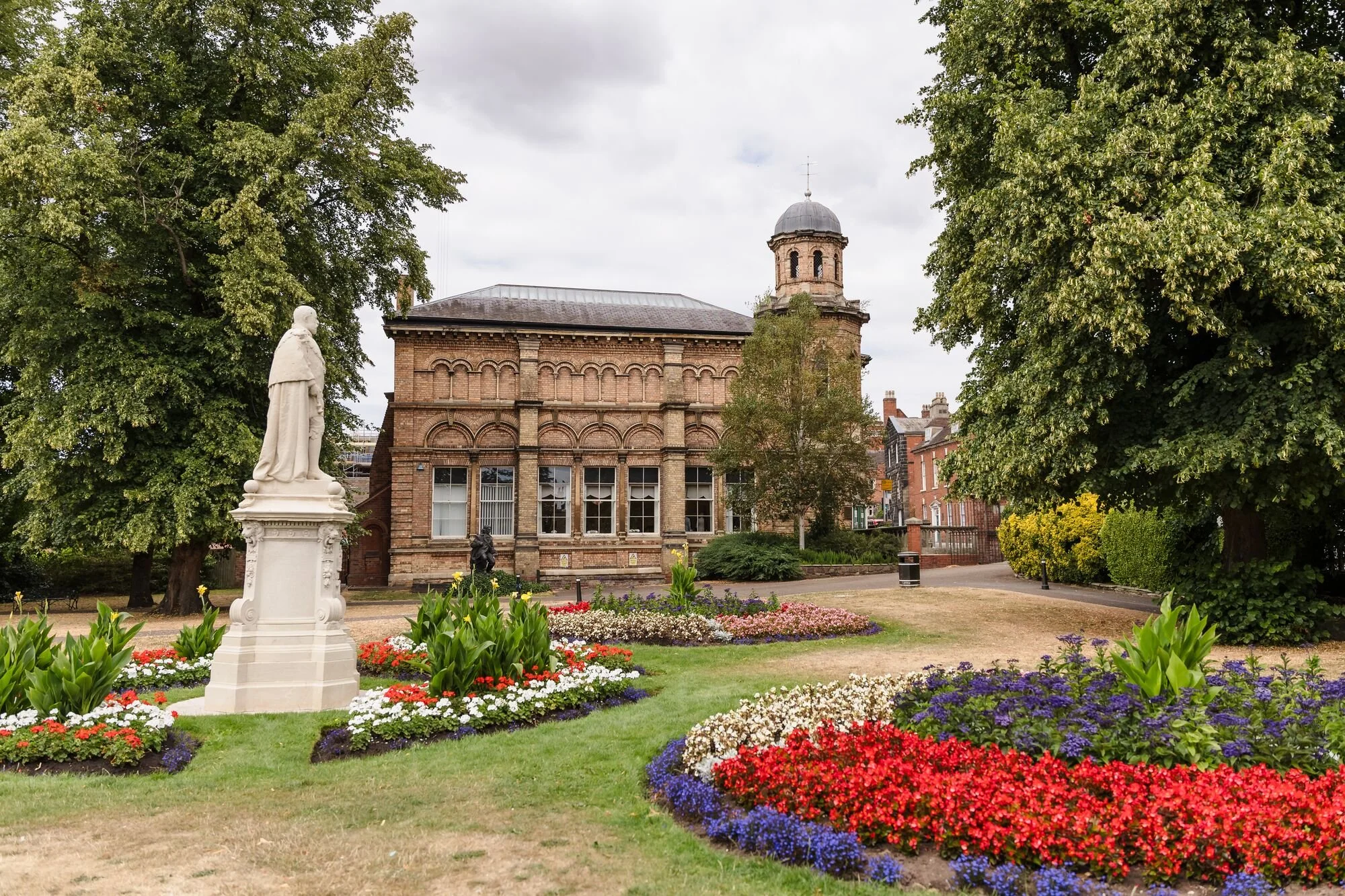 Lichfield Registry Office seen from Museum Gardens with summer flower beds, wedding photography by Once in a Lifetime Photography.