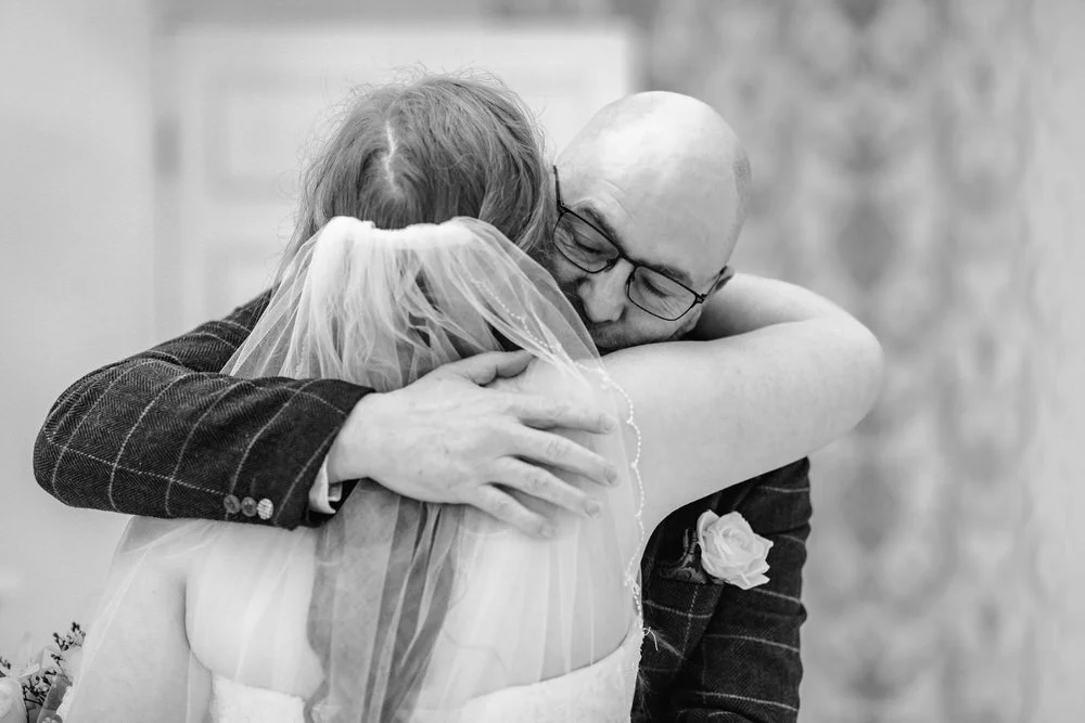 father of the bride giving the nbride a hug before the wedding