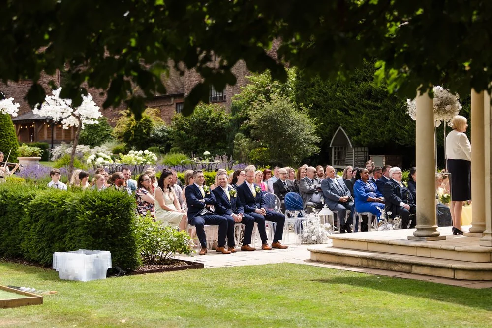 Candid photo of guests smiling during the wedding ceremony at Rowton Castle