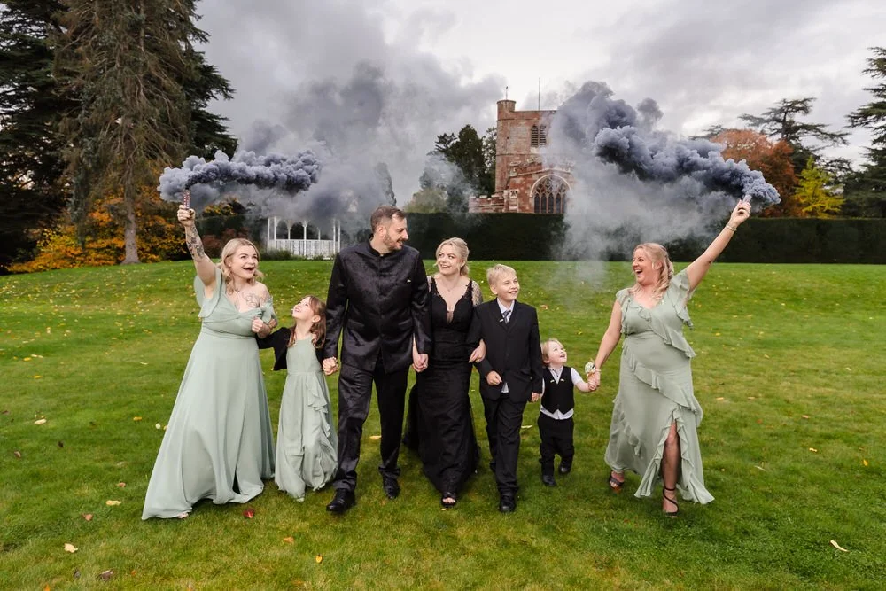 Creative wedding party portrait with purple smoke bombs in front of Arley House church, signature creative photography by Once in a Lifetime Photography Worcestershire