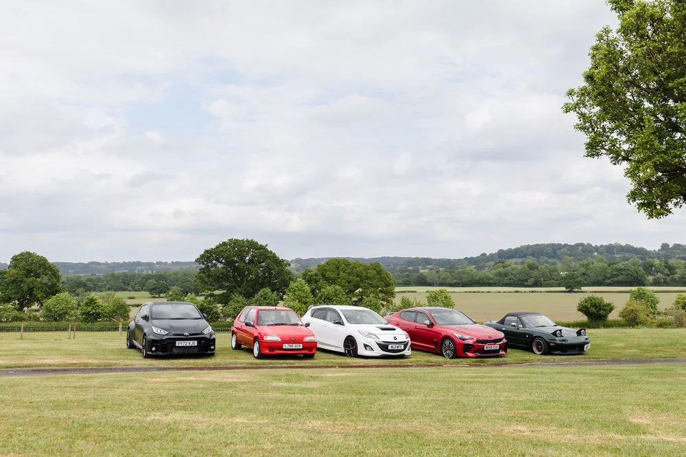 Impressive lineup of classic and modern sports cars at car enthusiast wedding including Toyota GT86, Peugeot 106 GTI, Mazda MX-5, and classic sports cars displayed at Bordesley Park wedding venue in Worcestershire countryside