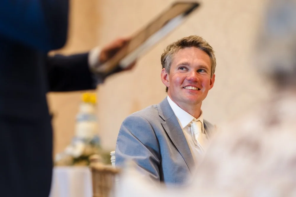 Groom Greg smiling during the wedding speeches at The Welcombe Hotel reception, Warwickshire.