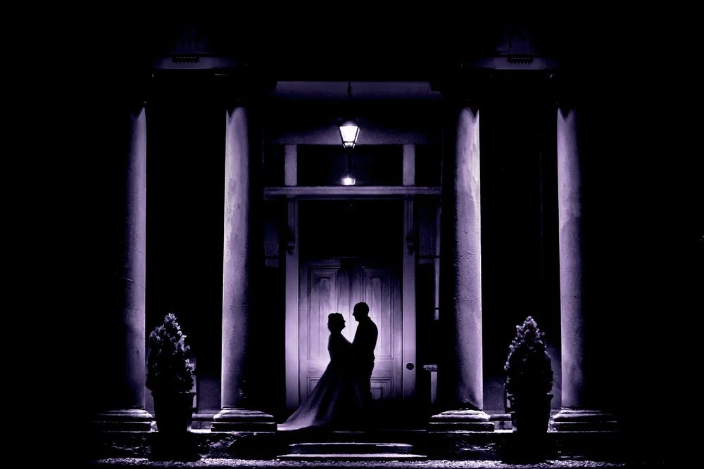 purple silhouette of bride and groom at a wedding