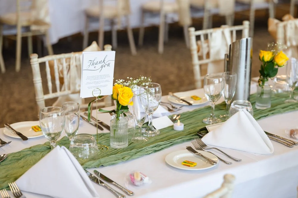 Wedding breakfast table setting with yellow roses at De Vere Cotswold Water Park