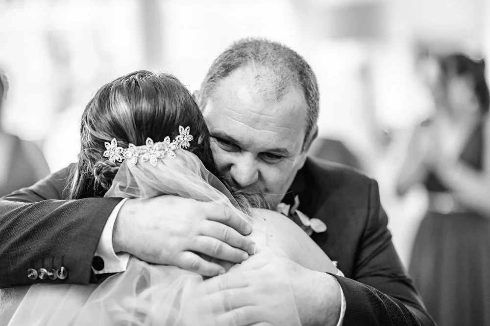 father of bride hugging his daughter
