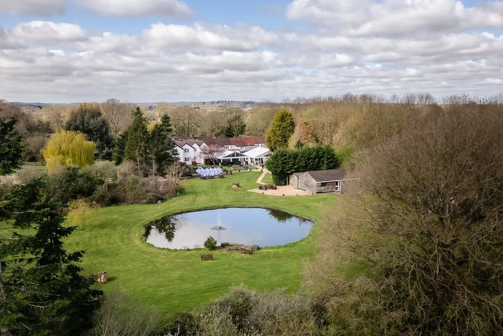 Drone photograph of The Limes Earlswood wedding venue with lake and outdoor ceremony chairs visible from above — Paul Hickey wedding photographer