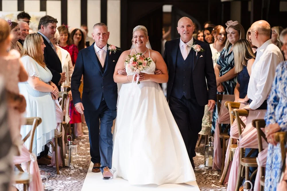 Bride Jess walking down aisle with family at Hogarths Stone Manor ceremony, Worcestershire wedding photography