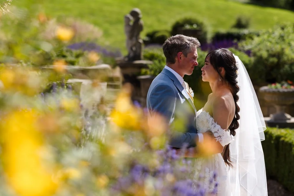 Christine and Greg framed by lavender and flowers in the Italian Garden at The Welcombe Hotel, Warwickshire.