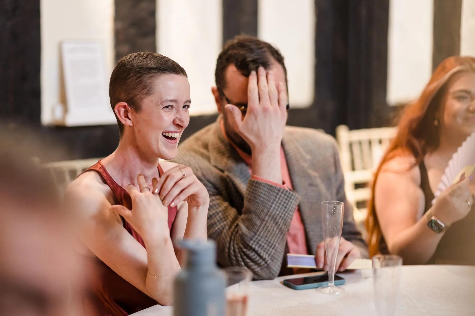 Guests laughing and covering their faces during the wedding speeches at The Commandery, Worcester, by Once in a Lifetime Photography